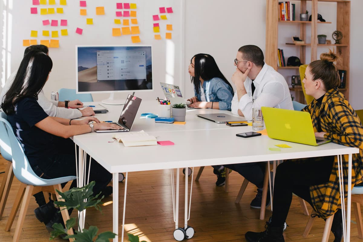 A team of professionals collaborating around a table with sticky notes
